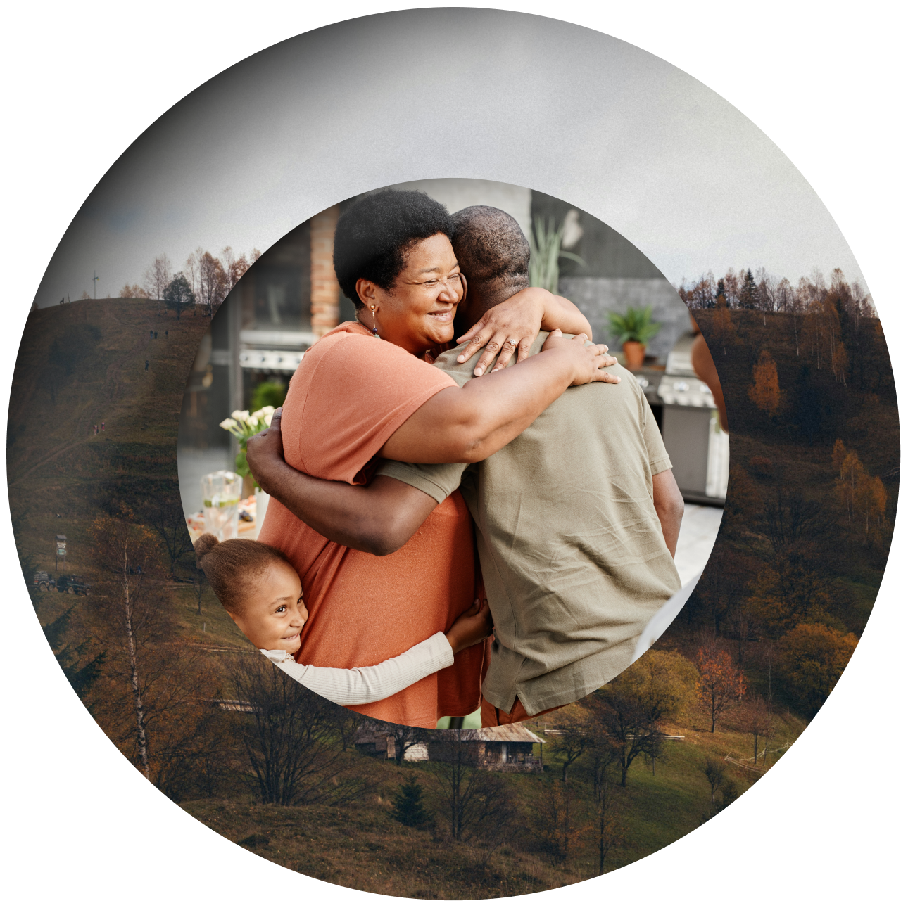 A smiling woman hugs a man while a young child clings to them, all framed in a circle overlaid on autumn trees and rolling hills.